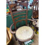 Two similar early 20th Century stained walnut framed Arts & Crafts style high back elbow chairs with