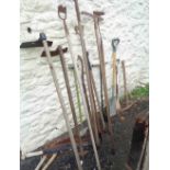 A quantity of assorted garden tools including billhooks, hoes, etc.