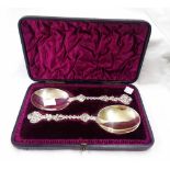 A cased pair of late Victorian silver anointing style spoons with wide bowls and ornate cast stems