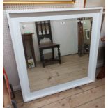 A modern white painted box framed wall mirror with bevelled plate