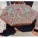 A Chinese style cast concrete garden table with repeat motifs in relief to top, set on faceted
