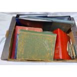 A box containing two albums with part contents of early 20th Century and other postcards, souvenir