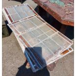 A quantity of old leaded stained glass panels comprising three large and two smaller all of matching