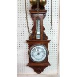 An early 20th Century stained oak framed barometer/thermometer with aneroid works