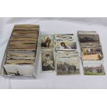 A box containing a collection of early 20th Century and other postcards including greetings,