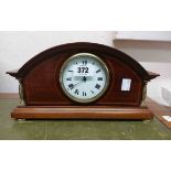 An Edwardian mahogany and strung cased timepiece with break arch top and flanking brass pillars,
