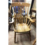 A modern blonde wood Windsor style high lathe back elbow chair with moulded sectional seat, set on