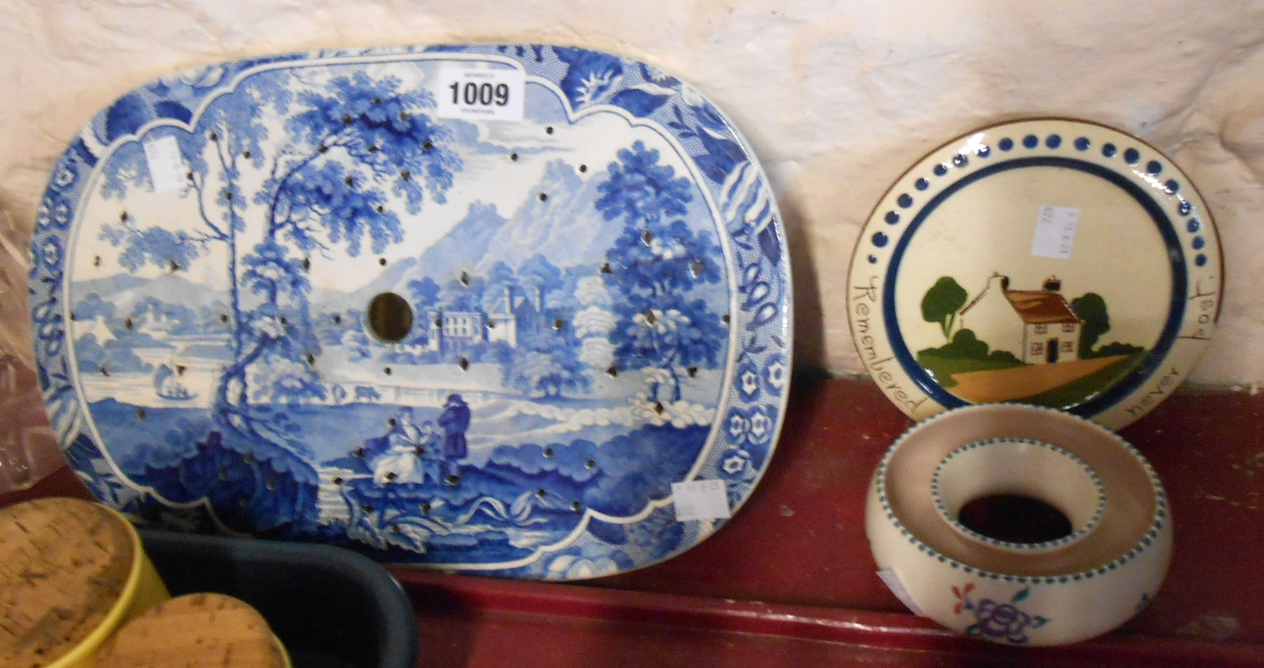 A 19th Century blue and white transfer printed strainer with a scene depicting a country house