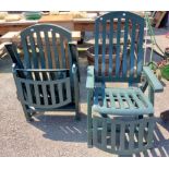 A pair of green plastic folding garden elbow chairs