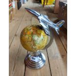 A modern Art Deco style revolving globe of the world with polished metal frame and aeroplane finial
