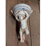 A vintage cherub pattern plaster wall shelf with cream painted finish