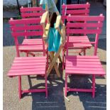 A set of four dark pink painted wood folding chairs with slatted backs and seats - sold with a