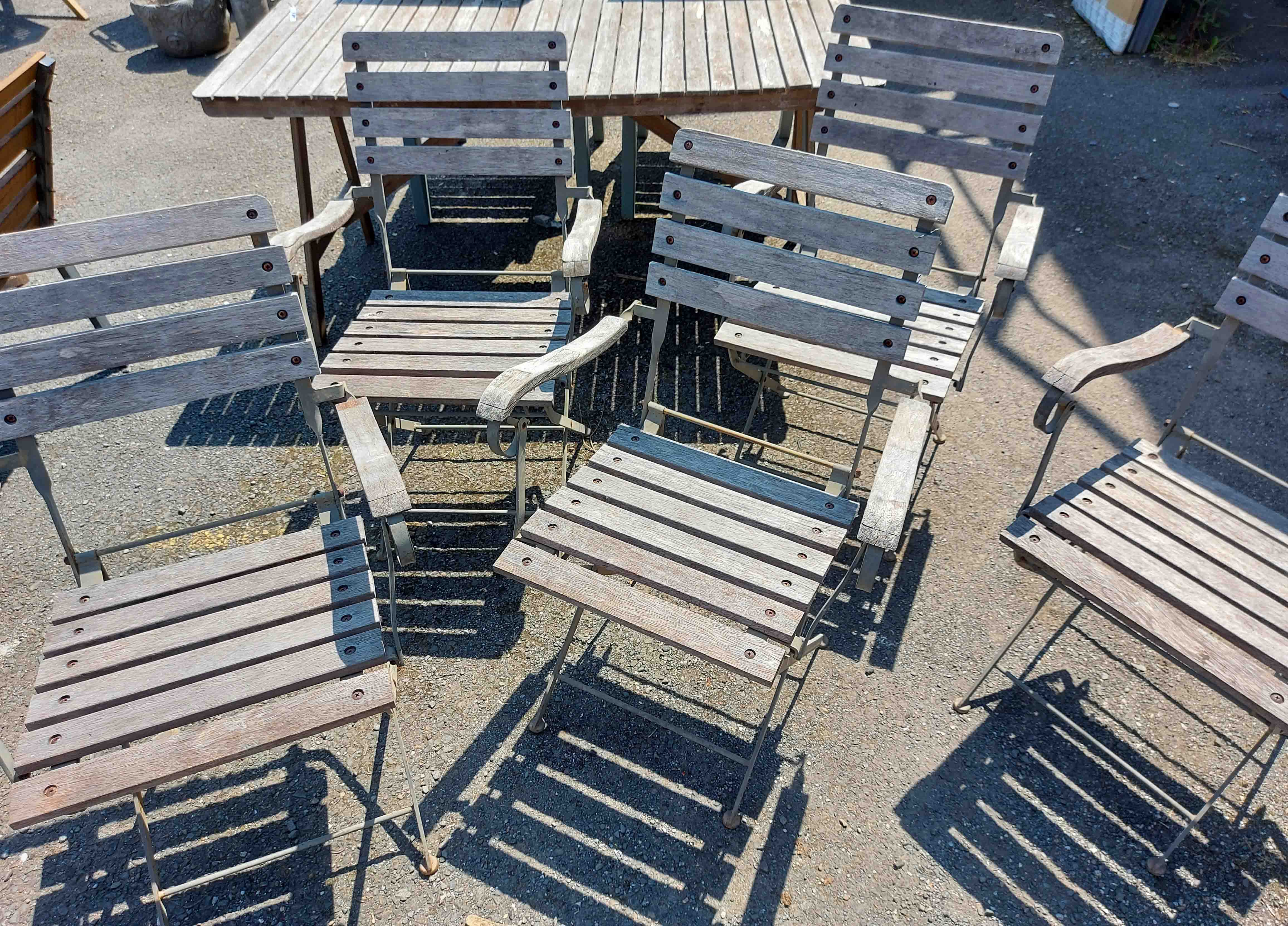 Five matching teak slatted folding garden elbow chairs with metal frames