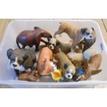 A crate containing a quantity of resin Boxer dog and other figurines - sold with four carved wood