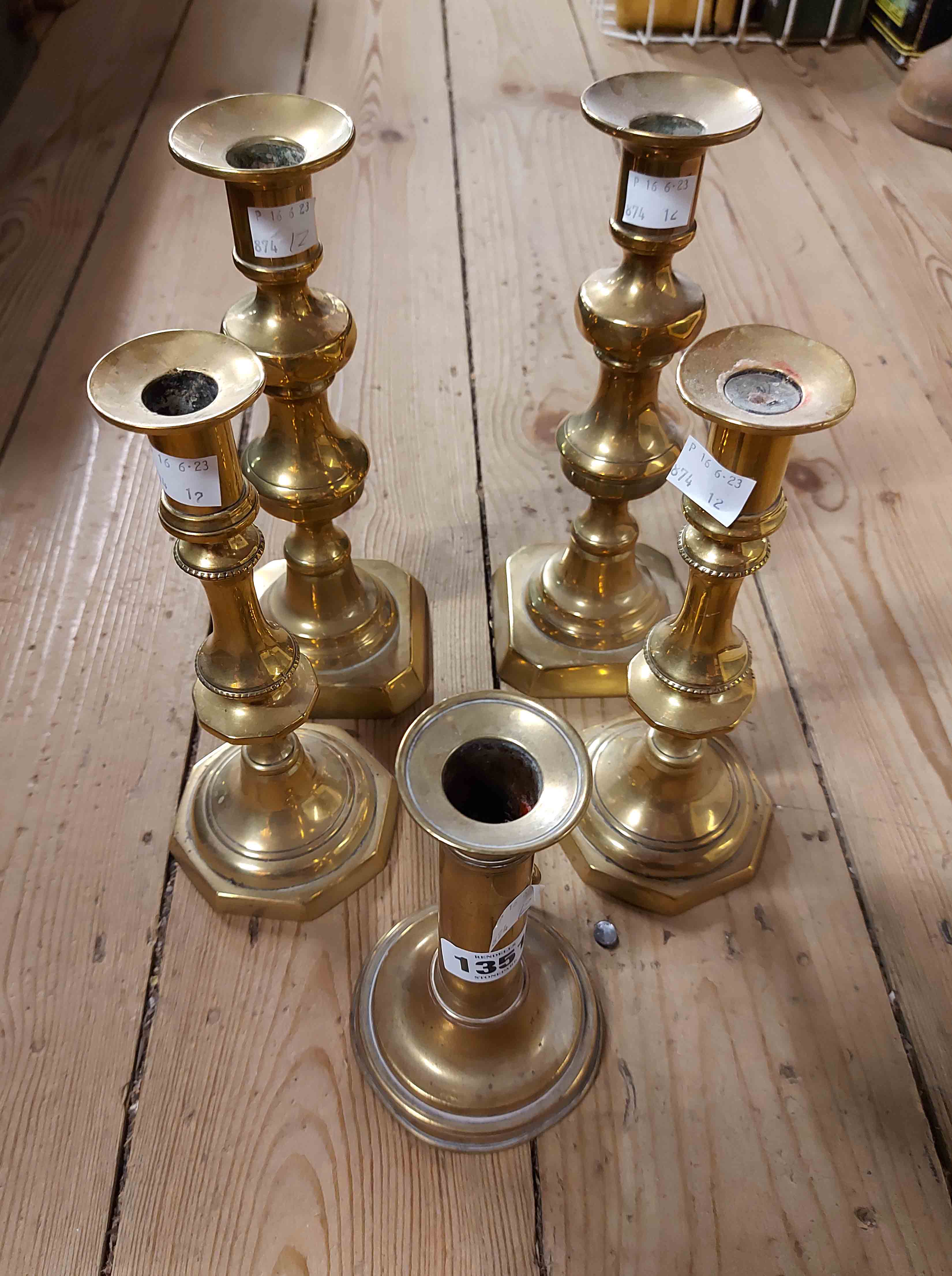 A pair of Victorian brass candlesticks - sold with a smaller similar and a single slide ejector