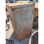 A vintage painted metal industrial cabinet enclosed by a hinged door