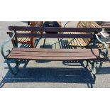 A 1.73m wooden slatted garden bench, set on wrought iron scroll ends