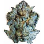 An antique bronze fountain head depicting putti over a grotesque fish - old repair to top