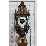 A reproduction stained wood and brass mounted Zan Dam wall clock with Atlas holding the world finial