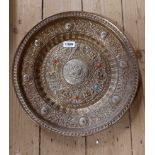 An Eastern brass dish with white metal and chased decoration and applied cabochon