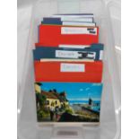 A plastic tub containing a collection of 20th Century postcards including Devon, Hampshire,