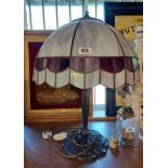 A modern table lamp in the Art Nouveau style with cast metal base and large Tiffany style shade -