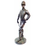 A cast bronze figurine depicting a 19th Century military gentleman holding a cane