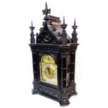 A late 19th Century Gothic Revival ornate ebonised cased table clock of architectural design with