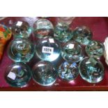 Twelve old bottle glass paperweights with internal enamel decoration of various size and form -
