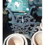 A pair of green painted cast iron bench ends