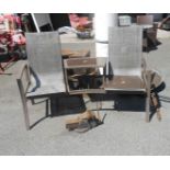 A modern metal framed garden bench with central table and mesh back