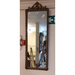 A reproduction ornate gilt framed narrow oblong wall mirror with Georgian style pediment and border