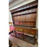 A 1.82m 18th Century oak two part potboard dresser with original forged iron hooks to the three
