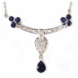 A 585 (14ct.) white gold pendant necklace, set with seven sapphires and numerous small diamonds in a