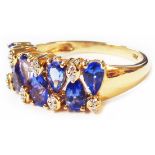 A marked 18k yellow metal ring set with two rows of alternating tanzanites and tiny diamonds -