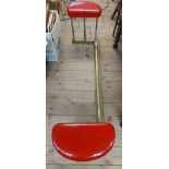 An early 20th Century 1.6m brass club fender with red upholstered end seats