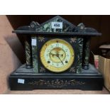 A late Victorian black slate and marble cased mantel clock with visible escapement and Ansonia