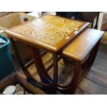 A harlequin nest of three retro teak tea tables, the largest with tile inset top, all set on