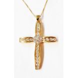 A marked 14k yellow metal diamond encrusted cross shaped pendant with channel set and clustered