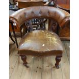 A 19th Century mahogany framed bow elbow chair with worn button back rexine upholstery and pierced