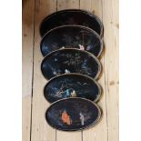 A set of five old graduated Japanese lacquer trays, each decorated with figures in a landscape -