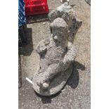 A vintage concrete garden ornament in the form of a gnome seated in an armchair