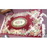 A Chinese washed wool rug with rose motifs on red ground - 1.55m X 90cm