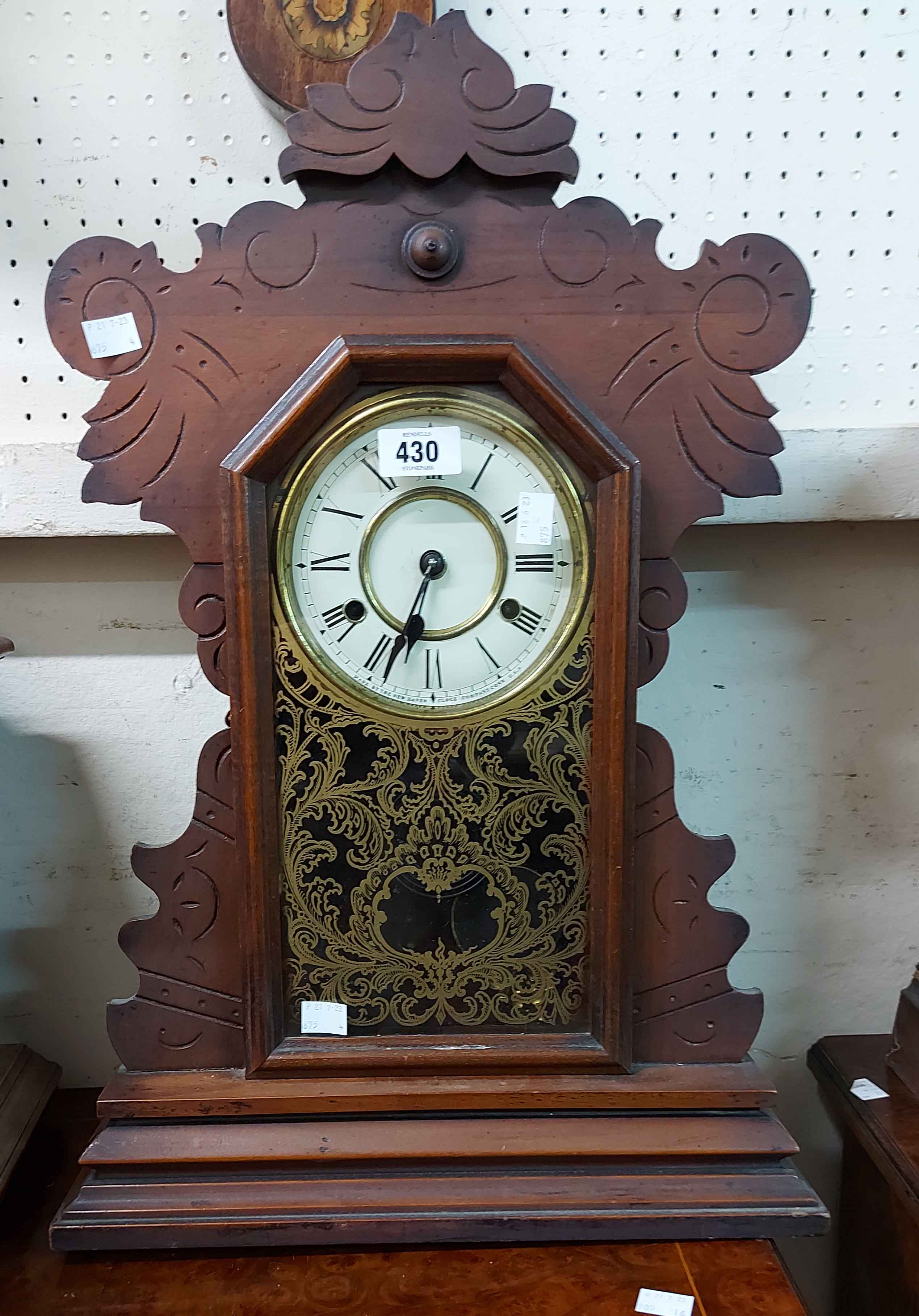 An American stained wood cased 'gingerbread' shelf clock with decorative glazed panel door and New