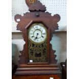 An American stained wood cased 'gingerbread' shelf clock with decorative glazed panel door and New