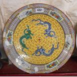 A large 20th Century Chinese dish with three dragons on a yellow ground and decorative border and