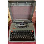 A vintage Empire Aristocrat portable typewriter in original metal carry case