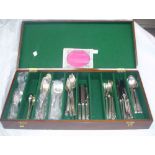 A polished wood canteen containing a part set of 'Springtime' pattern silver plated cutlery
