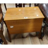 A retro style teak effect sewing box with lift-top, part fitted interior and concertina action,