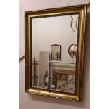 A reproduction gilt framed bevelled oblong wall mirror with beaded border - slight damage to frame